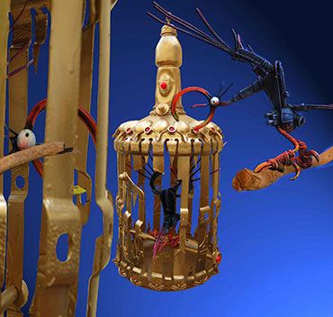 A guardare stanno quelli in gabbia, sculture in plastica